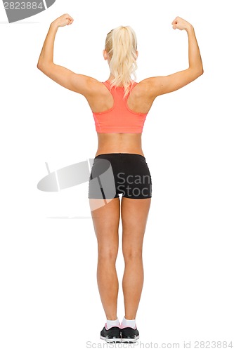 Image of sporty woman from the back flexing her biceps