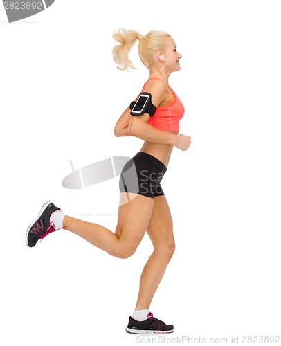 Image of sporty woman running with smartphone and earphones