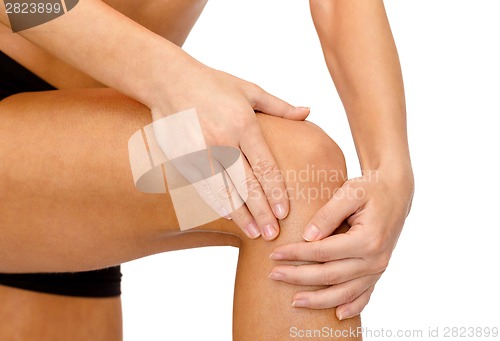 Image of close up of female hands holding knee