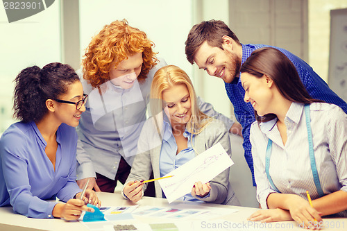 Image of smiling creative team looking at sketch