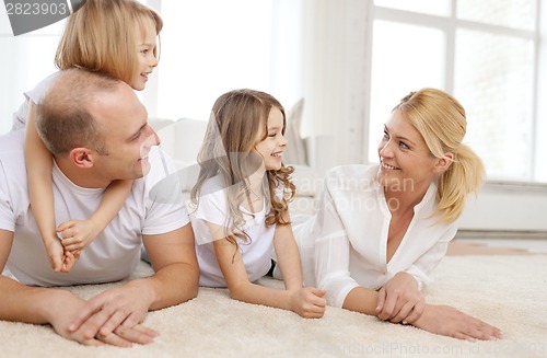 Image of parents and two girls lying on floor at home