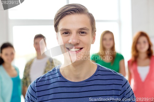 Image of smiling students with teenage boy in front