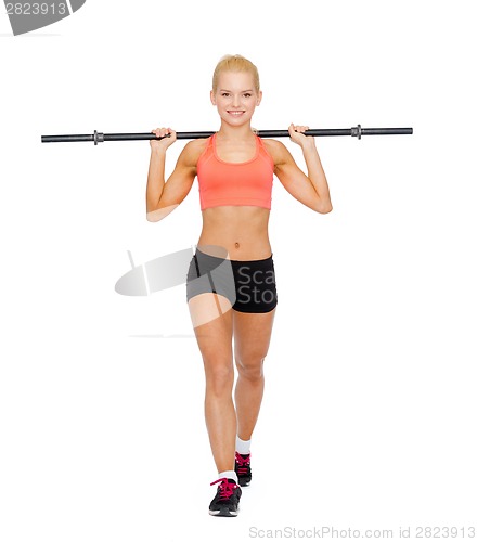 Image of smiling sporty woman exercising with barbell