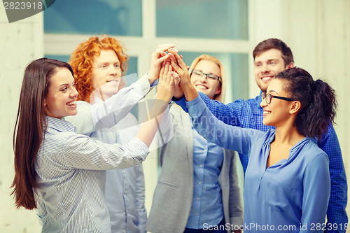 Image of creative team doing high five gesture in office