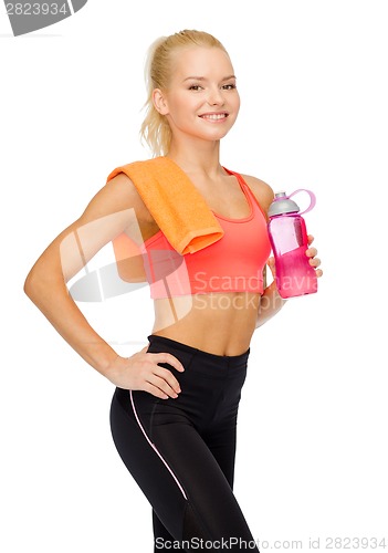 Image of smiling sporty woman with water bottle and towel