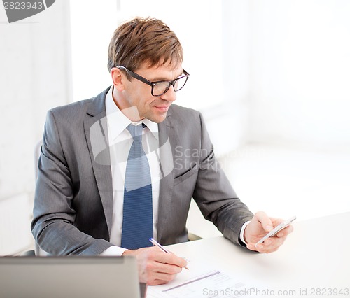 Image of businessman working with laptop and smartphone