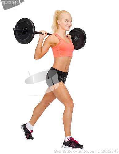 Image of smiling sporty woman exercising with barbell