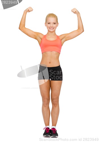 Image of smiling sporty woman flexing her biceps