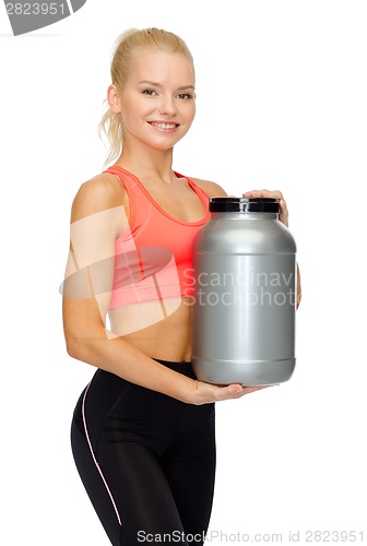 Image of smiling sporty woman with jar of protein