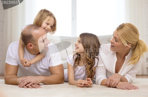 Image of parents and two girls lying on floor at home