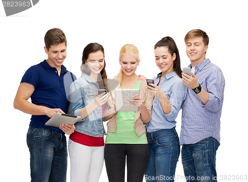 Image of smiling students using smartphones and tablet pc