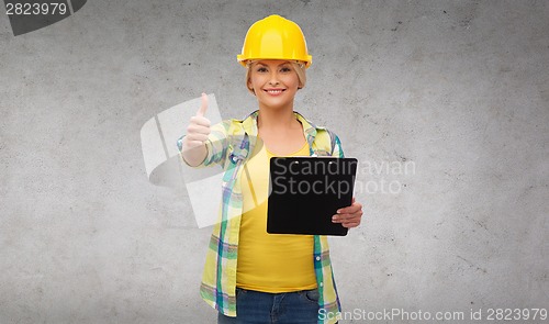 Image of smiling woman in helmet with clipboard