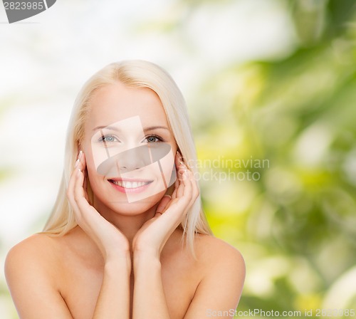 Image of face of beautiful woman touching her face skin