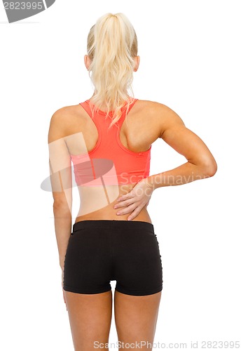 Image of sporty woman touching her back