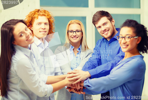 Image of team with hands on top of each other in office