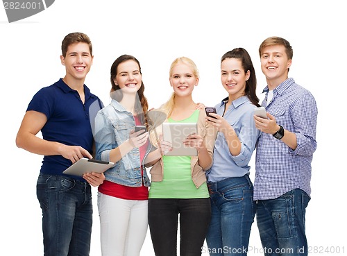 Image of smiling students using smartphones and tablet pc