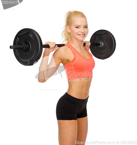 Image of smiling sporty woman exercising with barbell