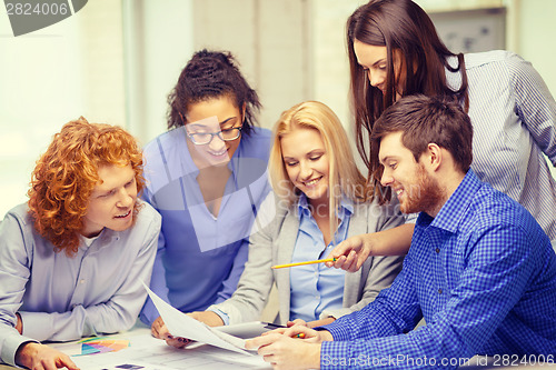 Image of smiling team with color samples at office