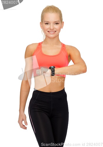 Image of smiling woman with heart rate monitor on hand