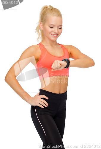 Image of smiling woman with heart rate monitor on hand