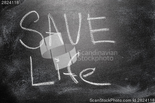 Image of Handwritten message on chalkboard writing message Save Life