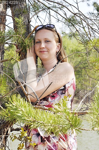 Image of the happy woman costs at a pine.