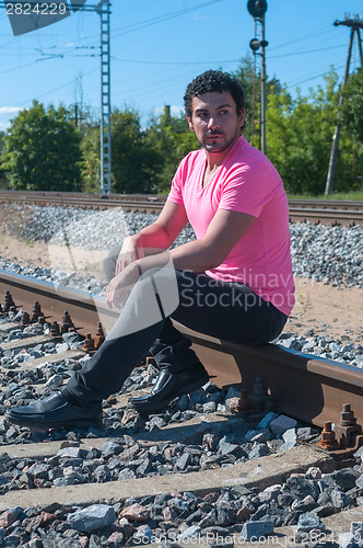 Image of Young man sitting on the rail track