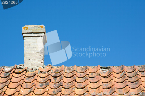 Image of Chimney at an old broken tiled roof