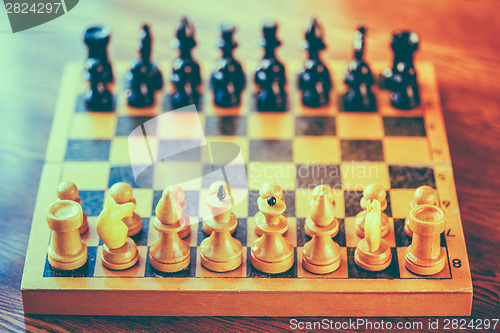 Image of Ancient wooden chess standing on chessboard