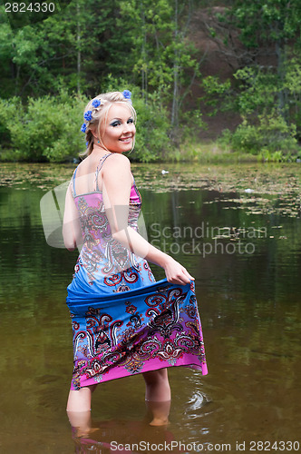 Image of Beautiful woman standing in pond