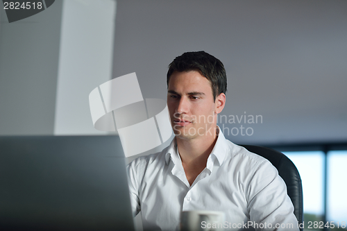 Image of business man working on laptop computer at home