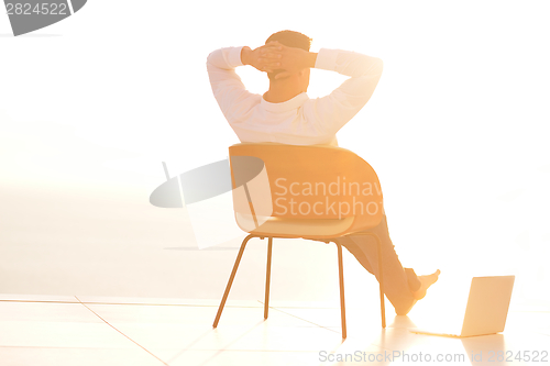 Image of relaxed young man at home on balcony