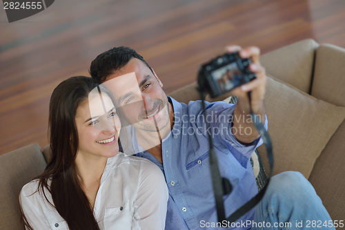 Image of couple playing with digital camera at home