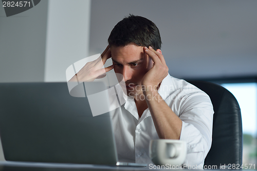 Image of business man working on laptop computer at home