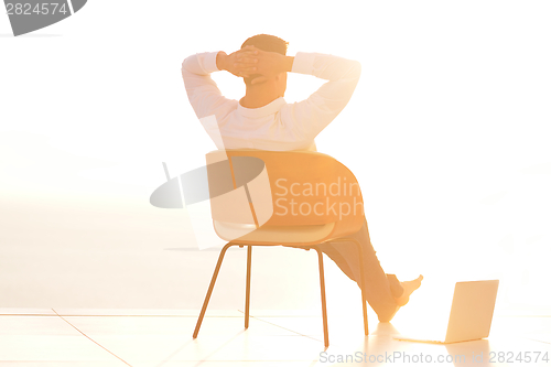 Image of relaxed young man at home on balcony