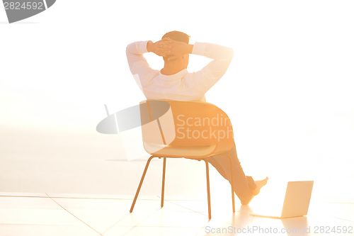 Image of relaxed young man at home on balcony