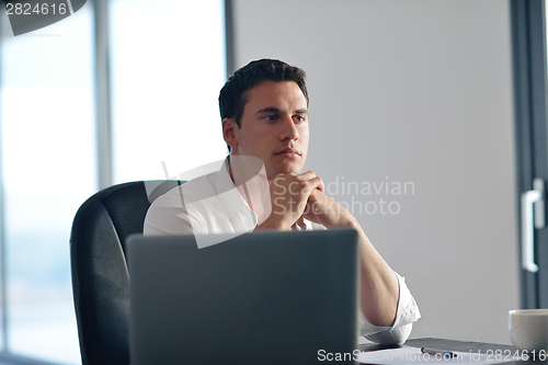Image of business man working on laptop computer at home