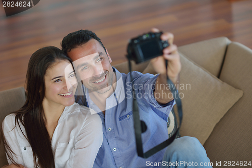 Image of couple playing with digital camera at home