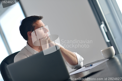 Image of business man working on laptop computer at home