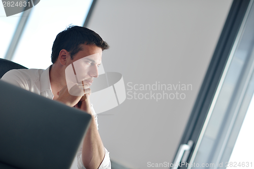 Image of business man working on laptop computer at home