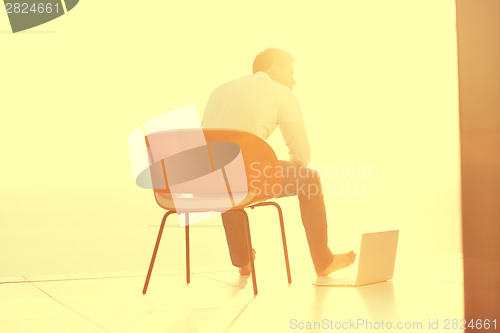 Image of relaxed young man at home on balcony