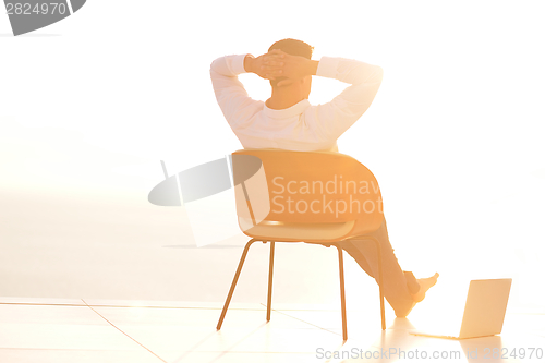 Image of relaxed young man at home on balcony