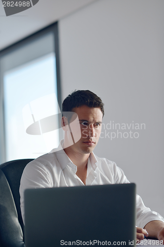 Image of business man working on laptop computer at home