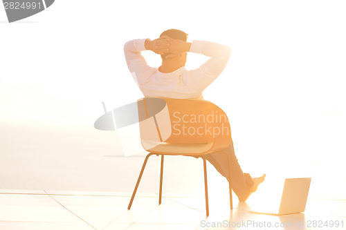 Image of relaxed young man at home on balcony