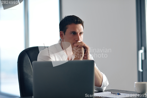 Image of business man working on laptop computer at home
