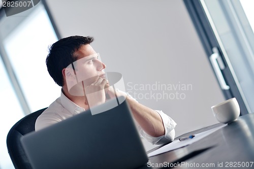 Image of business man working on laptop computer at home