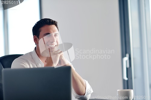 Image of business man working on laptop computer at home