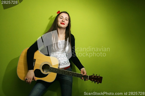 Image of Brunette posing with guitar