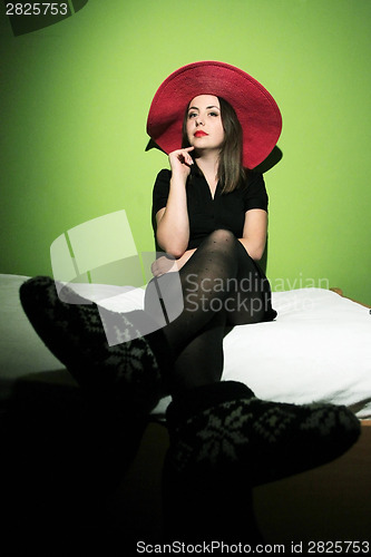 Image of Woman with pink straw hat on bed