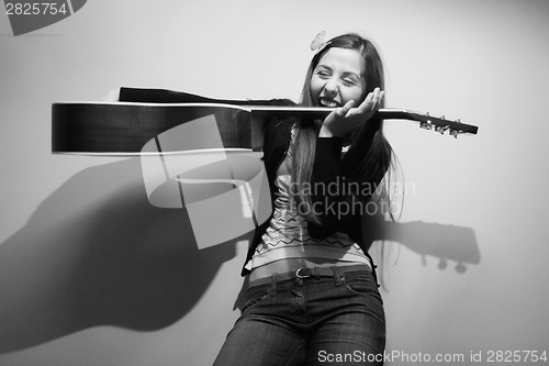 Image of Brunette playing with guitar black and white